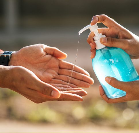one human spray sanitizer to another on hand
