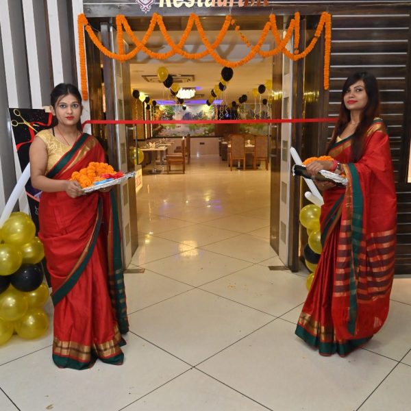 Two girls standing outside the restaurant with flowers for the welcoming